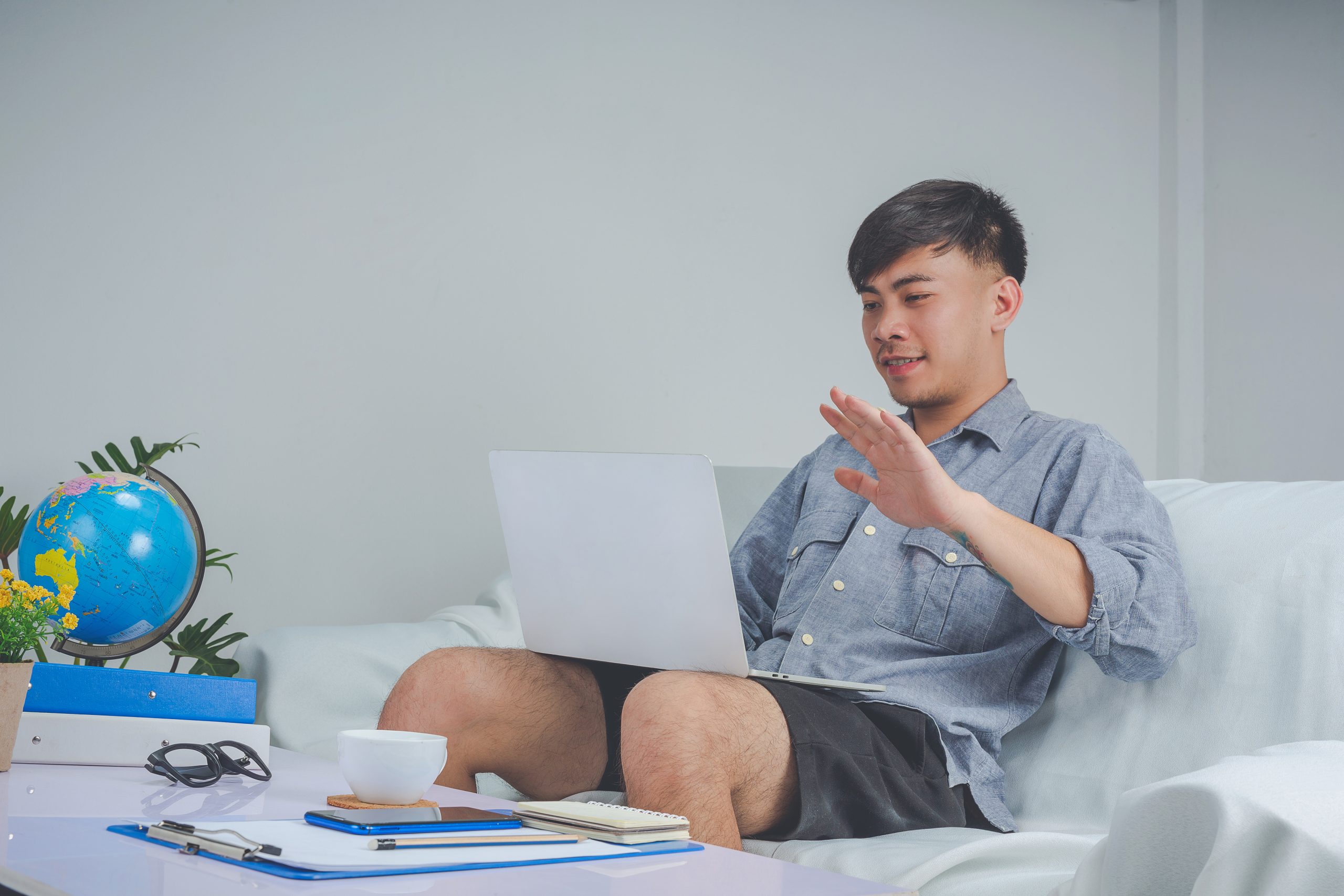 Young boy is working with labtop and busy on his working on sofa at home